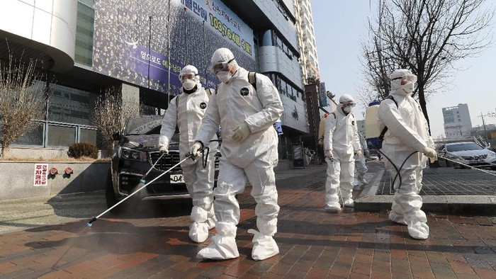 Petugas dengan pakaian pelindung menyemprotkan disinfektan di kawasan kota Daegu, Korsel (Kim Jun-beom/Yonhap via AP)