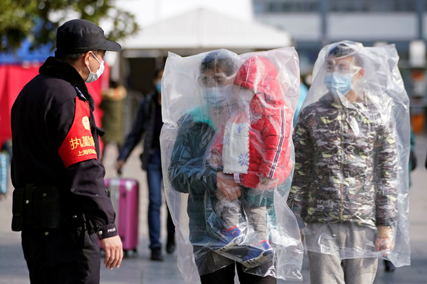 Warga China menggunakan plastik besar untuk mencegah tubuhnya terpapar virus corona. Foto/Reuters/China Daily