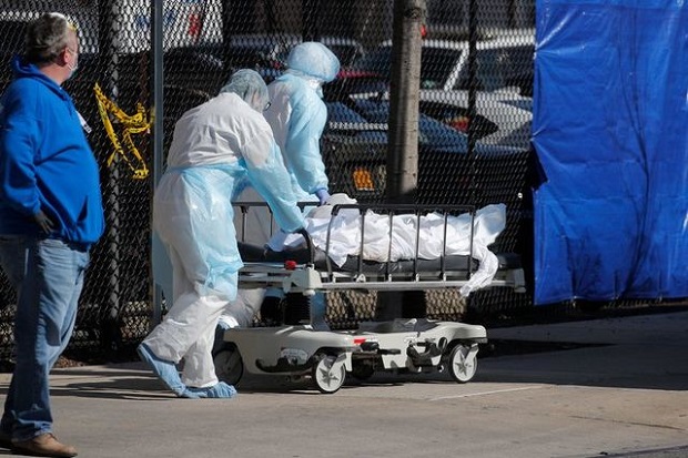 Petugas kesehatan mendorong jasad korban COVID-19 ke kamar mayat darurat di luar Wyckoff Heights Medical di Brooklyn, New York, Amerika Serikat, 6 April 2020. Foto/REUTERS / Brendan Mcdermid