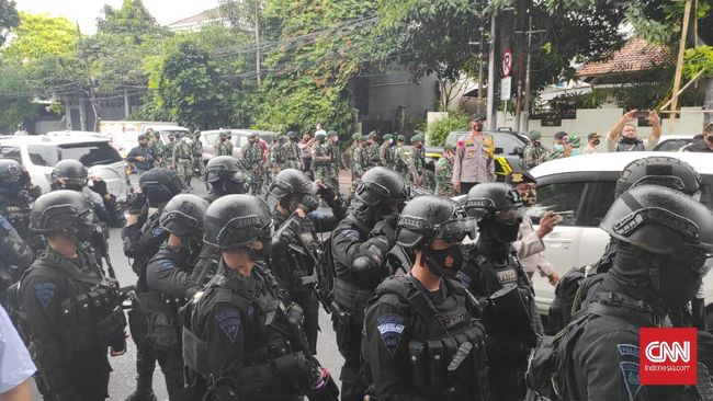 Aparat polisi berpakaian lengkap mendatangi kawasan Petamburan, Jakarta Pusat menuju Serkretariat Dewan Pimpinan Pusat Front Pembela Islam (DPP FPI). (CNN Indonesia/Damar Iradat)