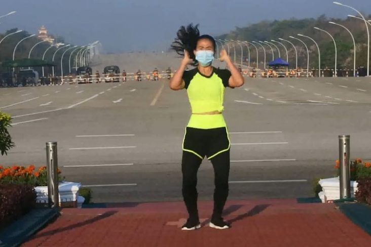 >Screengrab from FacebookGuru pendidikan jasmani Myanmar bernama Khing Hnin Wai melakukan gerakan aerobik diiringi lagu Ampun Bang Jago dengan di belakangnya, terdapat konvoi militer.