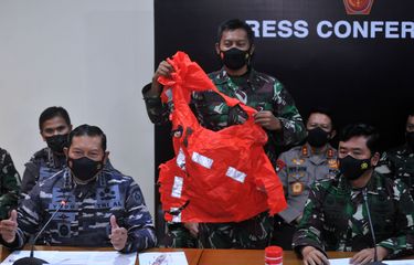 FIKRI YUSUF Panglima TNI Marsekal TNI Hadi Tjahjanto (kanan) dan Kepala Staf Angkatan Laut Laksamana TNI Yudo Margono (kiri) menunjukkan baju keselamatan awak kapal KRI Nanggala 402 yang ditemukan saat konferensi pers di Lanud I Gusti Ngurah Rai, Badung, Bali, Minggu (25/4/2021). KRI Nanggala 402 dipastikan tenggelam dan 53 awak kapalnya gugur di perairan utara Bali. ANTARA FOTO/Fikri Yusuf