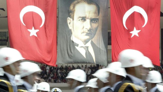 Foto pendiri Turki, Mustafa Kemal Ataturk, terpampang besar disamping Bendera Turki saat parade pemuda di Ankara pada 2004 lalu. (Foto: AFP/MUSTAFA OZER)