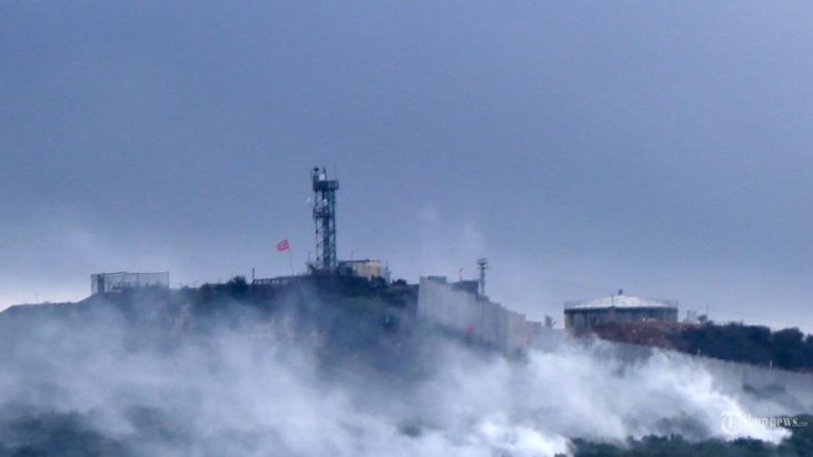 AFP/AFP Asap mengepul dekat situs militer Israel di desa perbatasan selatan Lebanon, Aita al-Shaab, menyusul penembakan yang dilakukan oleh Hizbullah. Minggu (15/10/2023) Eskalasi konflik berkembang melibatkan Hizbullah Lebanon dengan Israel hingga saling baku tembak mematikan di perbatasan dengan kelompok pejuanga Hamas yang didukung Iran mengaku bertanggung jawab atas serangan yang menurut Israel menewaskan seorang warga sipil, yang semakin meningkatkan ketegangan lintas batas selama perang Israel dengan militan yang berbasis di Gaza. (STR/AFP)